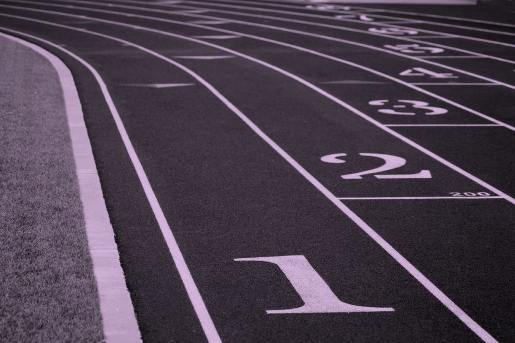 stylized two-tone photo of a running track at the starting line with numbers symbolizing the different starting points for the metadata journey.