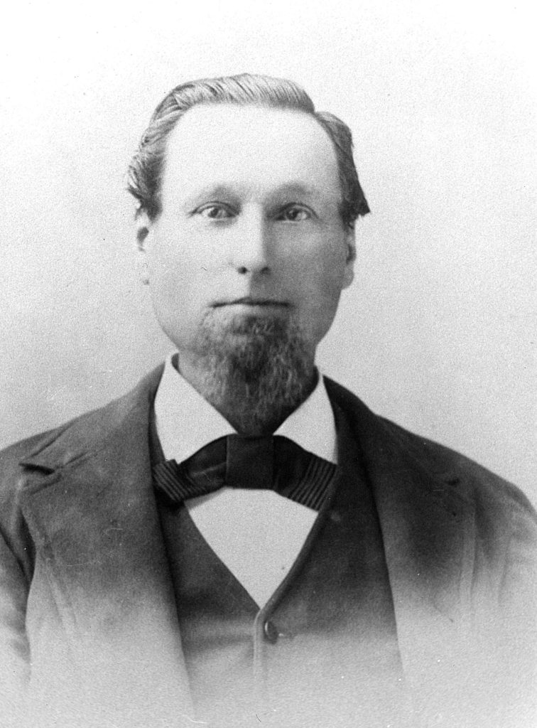 Black and white photo of a man with a beard. The photo appears to be from the late 1800s.