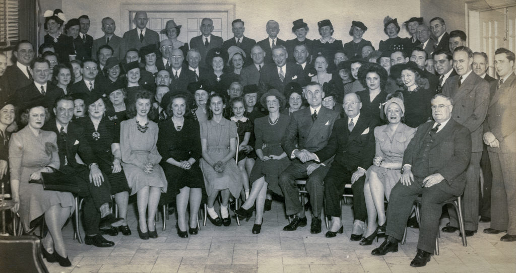 Black and white photo of a crowd of people in formal dress